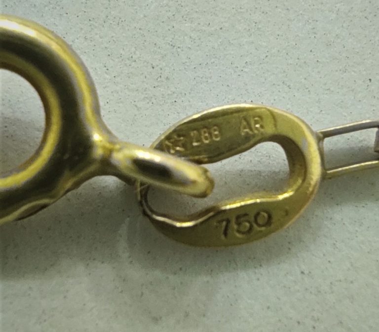 peça de ouro com marcação 750, indicando que a peça possui 18 quilates ou seja 750 permilagem