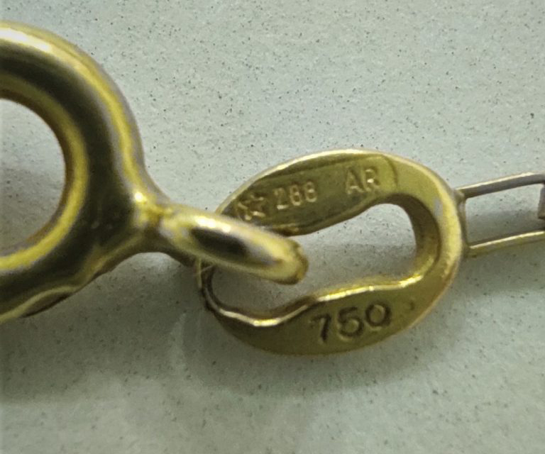 peça de ouro com marcação 750, indicando que a peça possui 18 quilates ou seja 750 permilagem